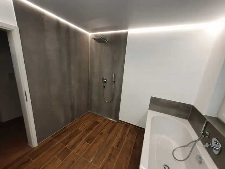 Bad mit Bodenfliesen in Holzoptik und Wanne