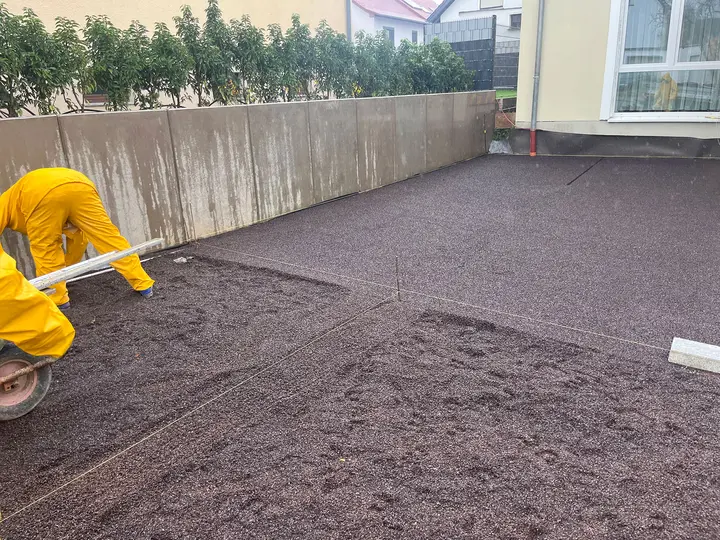 Mitarbeiter verteilt Splitt für die Einfahrt