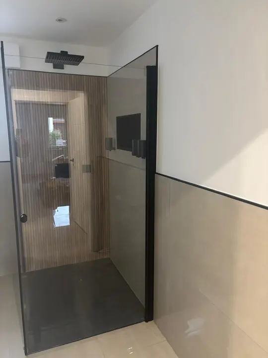 Fertige Dusche mit Glaswand und schwarzem Rahmen