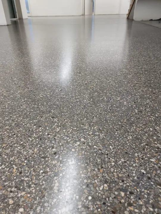 Terrazzoboden mit großen schwarzen Steinen in einem Holzhaus